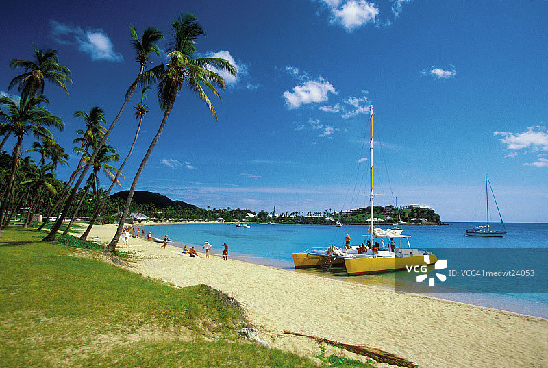 安提瓜莫里斯湾海滩的双体船和人群，加勒比海图片素材