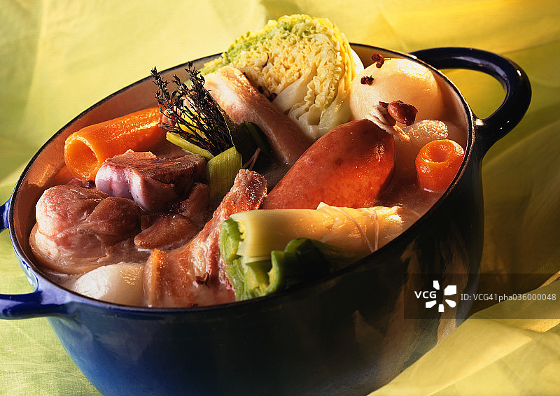 装满肉和蔬菜的蓝色炖锅图片素材