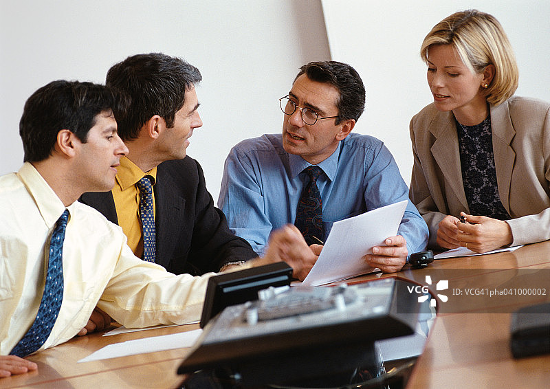 三位男商人和一位女商人正在查看文件图片素材