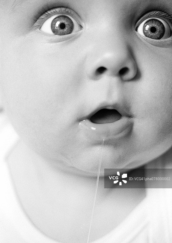 张着嘴流口水的黑白婴儿特写图片素材