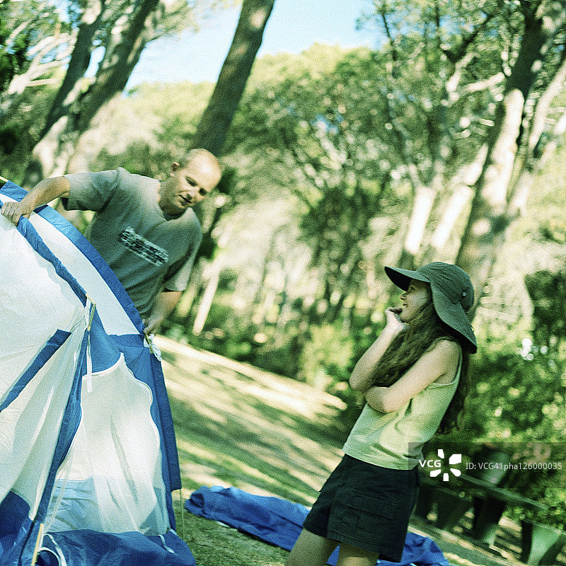 男人拿着帐篷，女孩在微笑图片素材