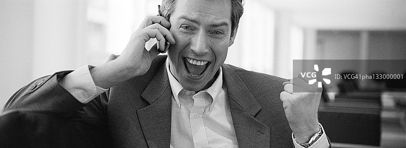 使用手机的非常快乐的商人（黑白照片）图片素材