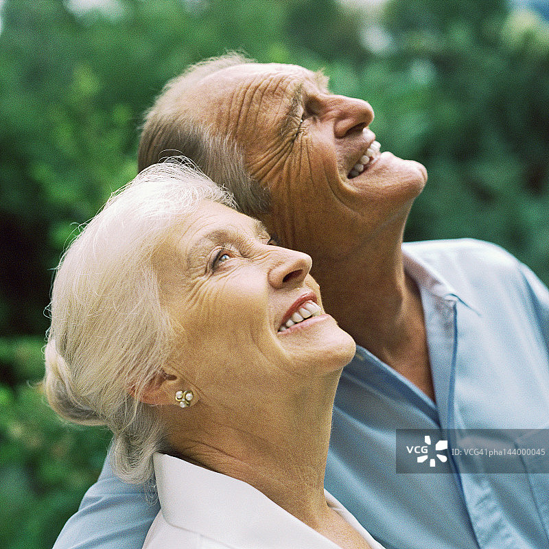手挽着手，抬头看的中年夫妇图片素材