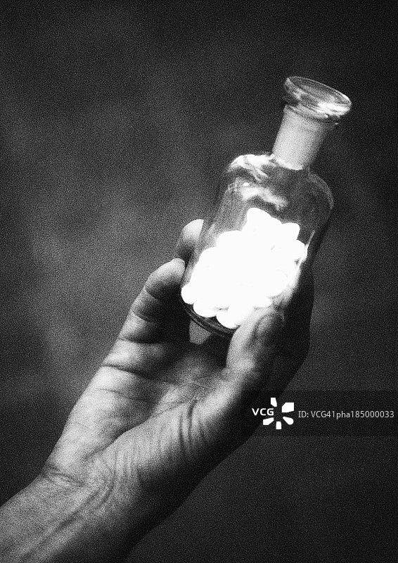 手持玻璃药瓶特写黑白照片图片素材