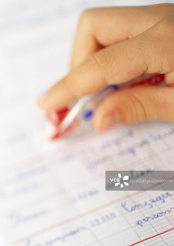 手握钢笔在课本上书写图片素材