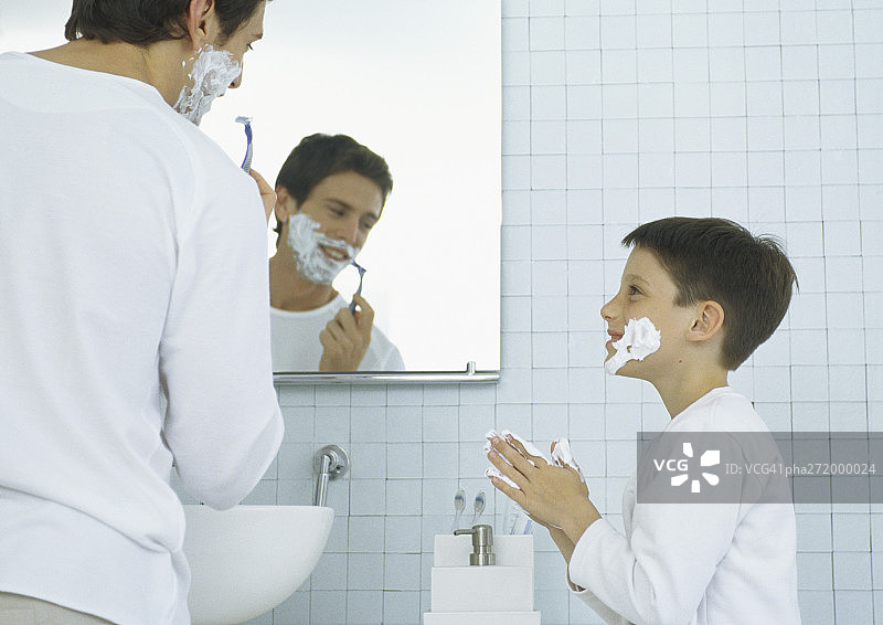 男人刮胡子，男孩脸上和手上涂满剃须膏图片素材