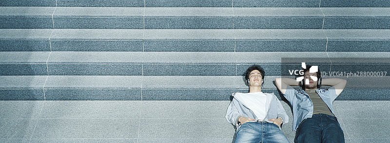 两个年轻男人躺在台阶上图片素材