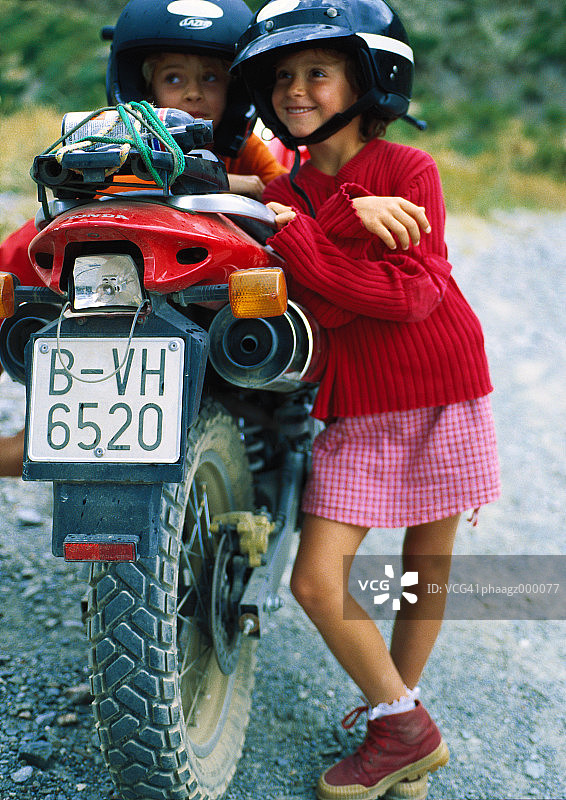 两个孩子靠在摩托车上图片素材