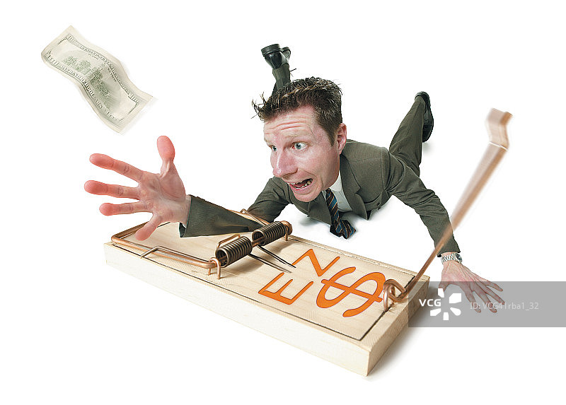 西装革履的白人商人被捕鼠器夹住手臂的概念漫画图片素材