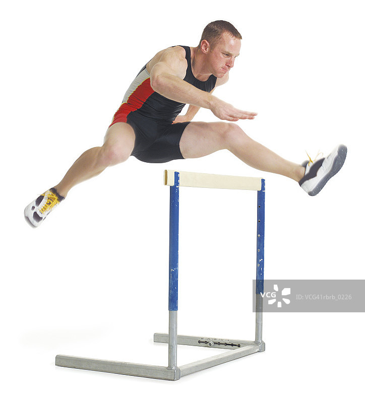 年轻白人男运动员在比赛中跨越栏架图片素材