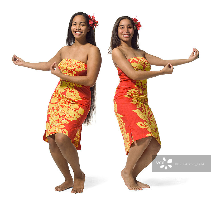两个身穿橙色碎花裙的波利尼西亚少女在跳传统舞蹈图片素材