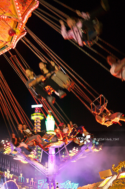 人们在集市上旋转和乘坐秋千的照片图片素材