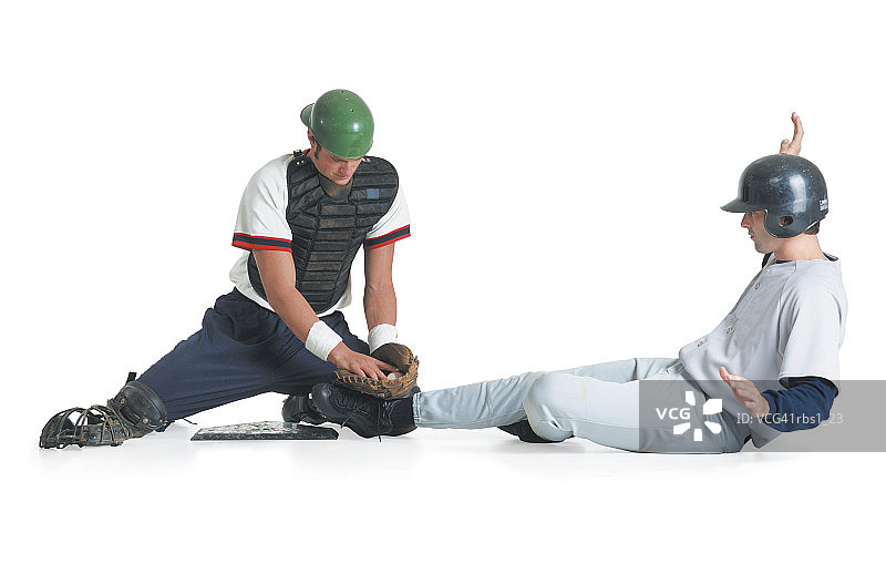 两名白人男子身穿棒球服，一人戴捕手护具，另一人戴击球头盔图片素材