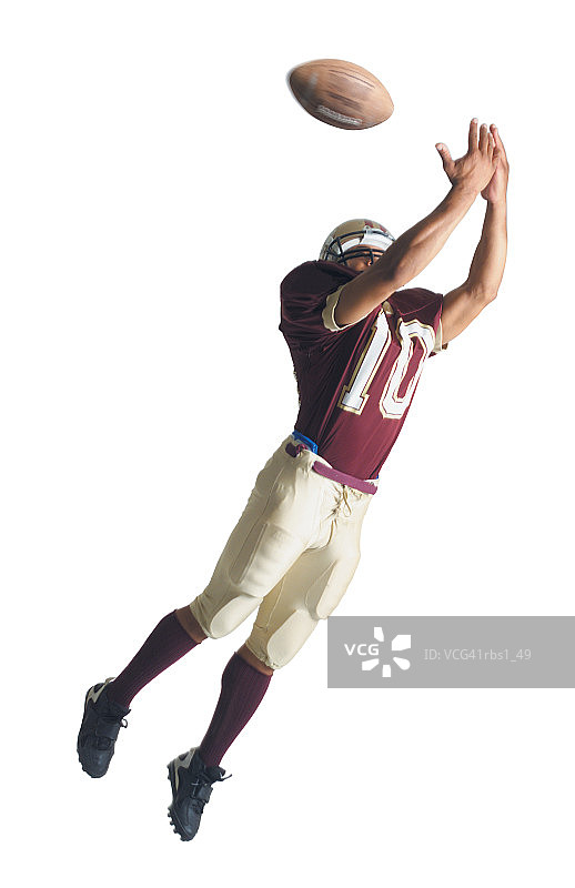 身穿红白制服的非裔美国橄榄球运动员跳起来伸出双臂接球图片素材