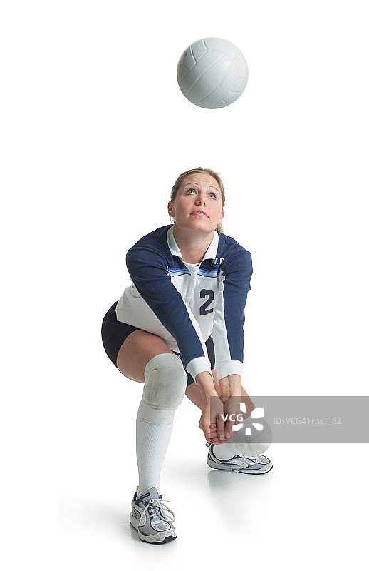 年轻白人女排球运动员跪姿准备击球图片素材