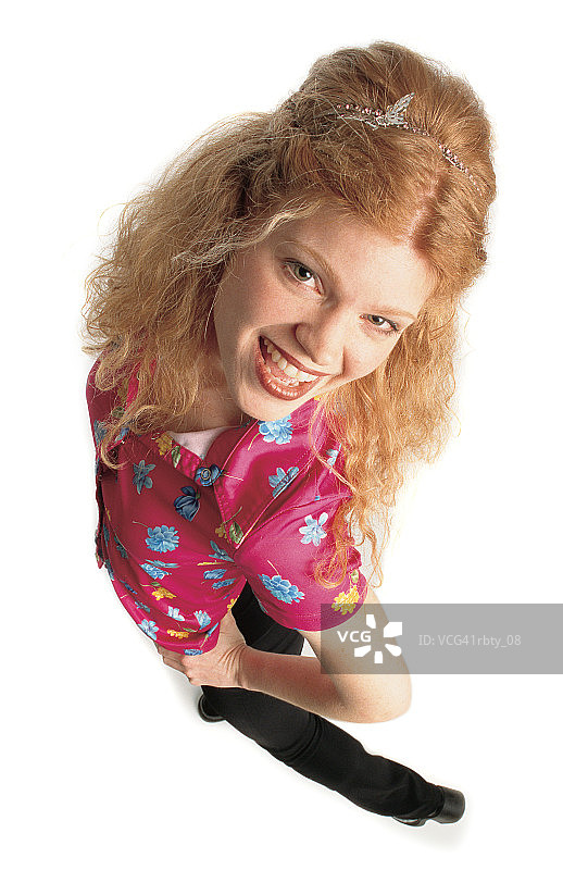 快乐的年轻白人女性，穿着花衬衫和黑色裤子，戴着头巾，对着镜头微笑图片素材