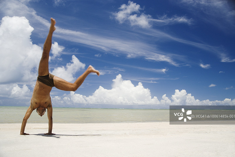 年长的男人在海滩上翻筋斗图片素材