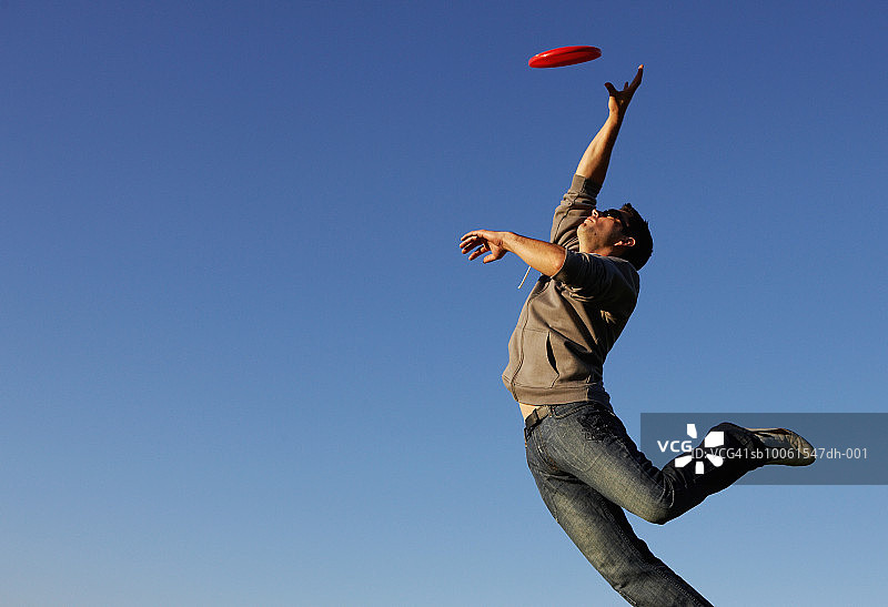 男人跳跃接飞盘图片素材