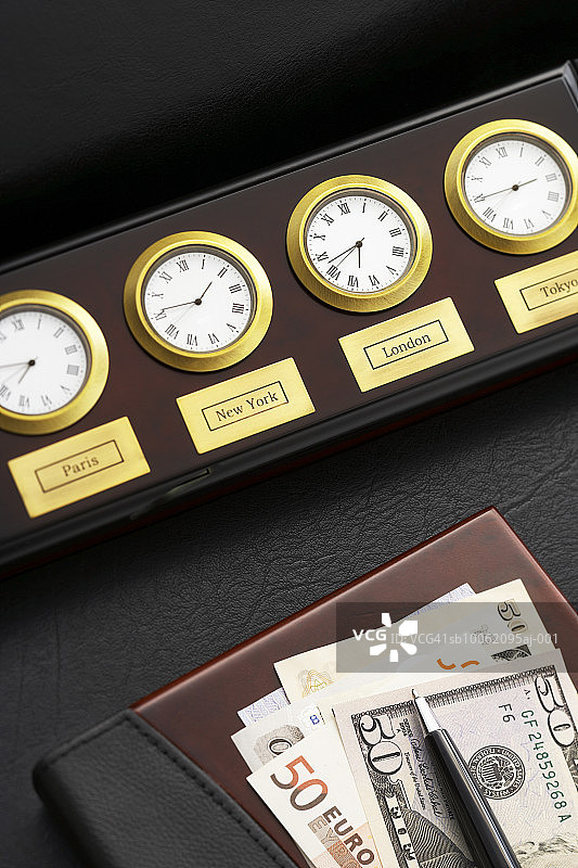 世界城市时钟：桌面笔记本纸币和笔图片素材
