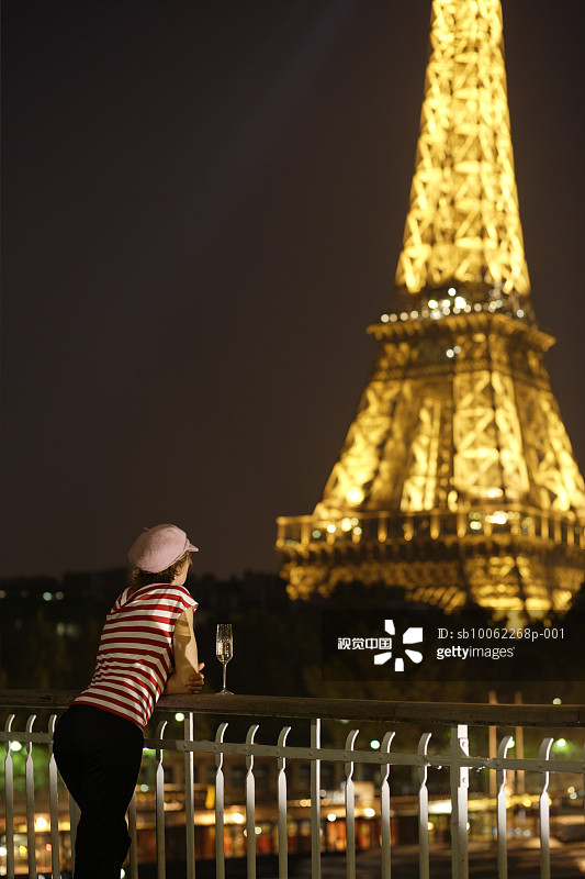 法国巴黎，女子在夜晚眺望埃菲尔铁塔图片素材