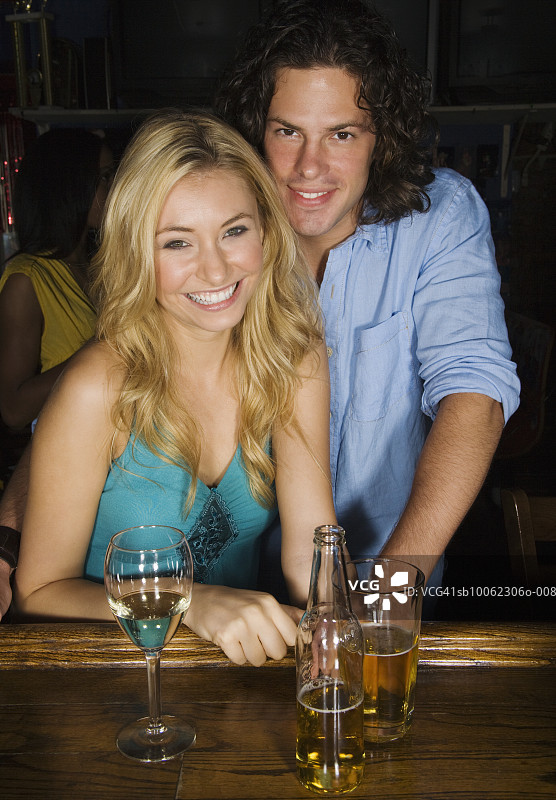 在酒吧微笑的一对年轻夫妇肖像图片素材