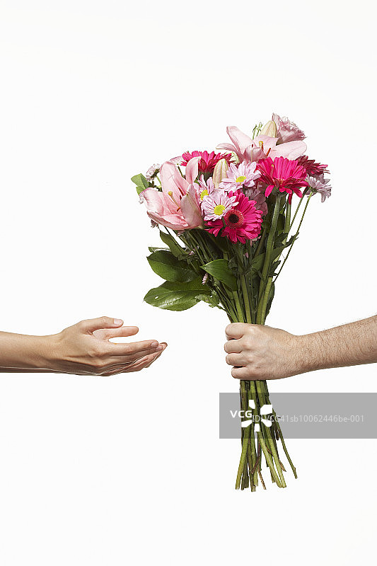 人们赠送粉色鲜花花束，手部特写，侧视图图片素材