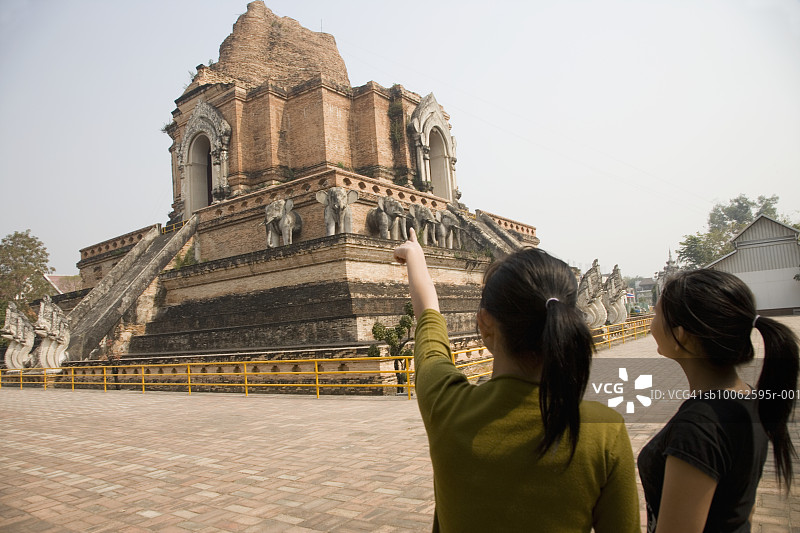 泰国清迈：辛寺，两名年轻女子观景，一人指向远方（后视图）图片素材