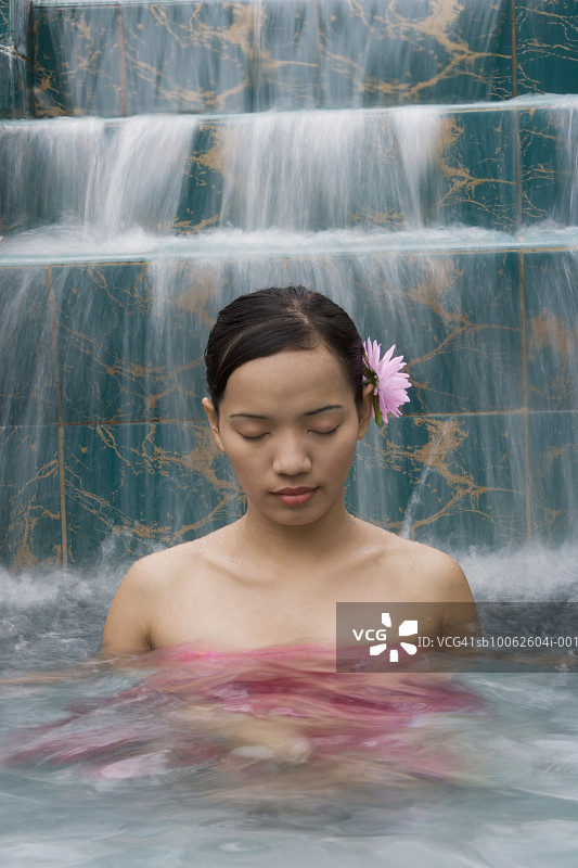 年轻女人在游泳池里闭着眼睛图片素材