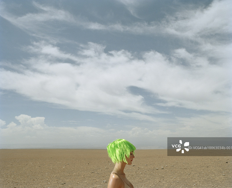 沙漠中留着绿色头发的年轻女人图片素材