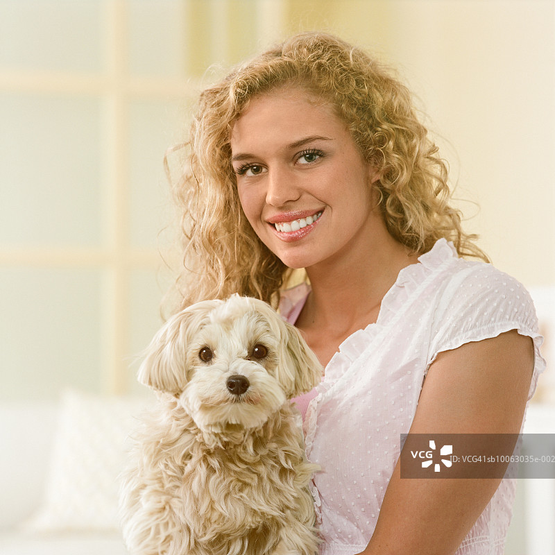 少女抱着马尔济斯贵宾犬微笑特写图片素材