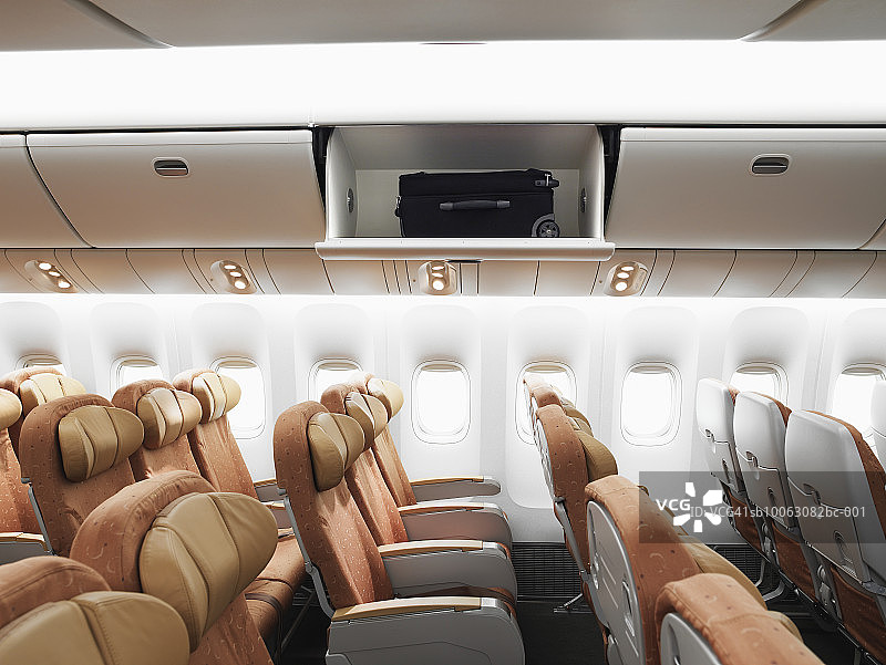 飞机内部：行李架上的单个行李，侧视图图片素材