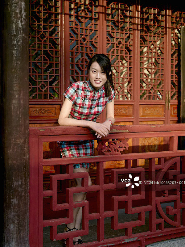 靠在木栏杆上的年轻女人肖像图片素材