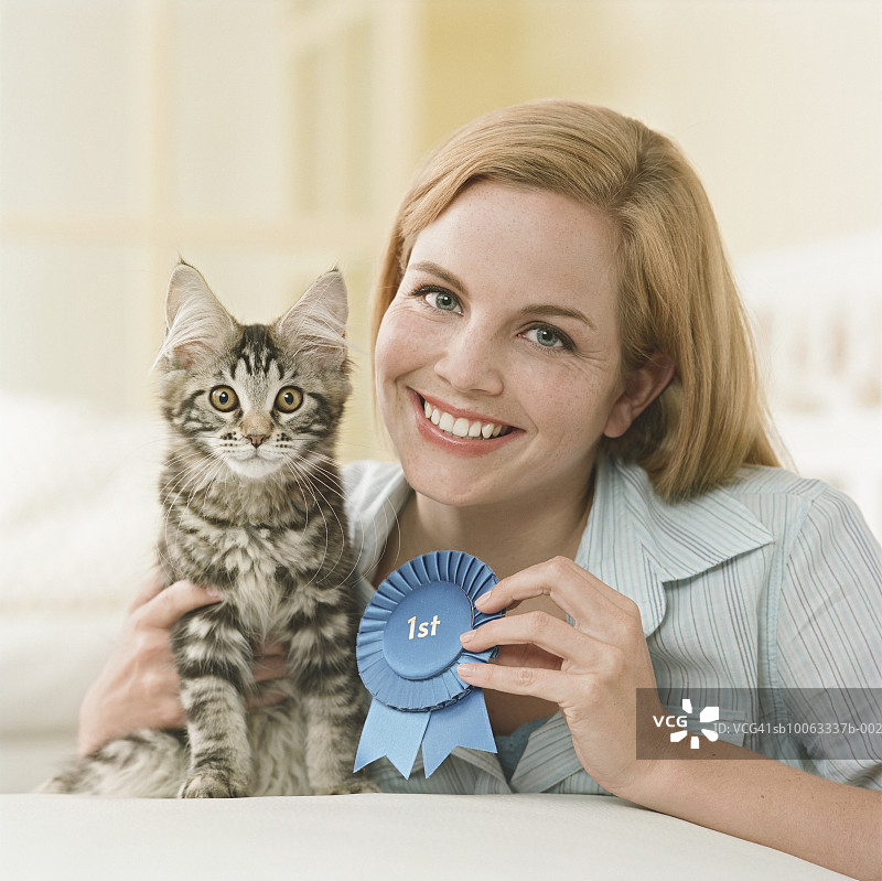 年轻女人抱着缅因猫和丝带肖像图片素材