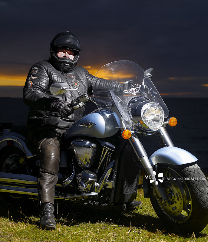 男人坐在摩托车上，肖像图片素材