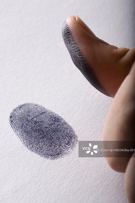 男人在纸上按指纹，拇指特写图片素材