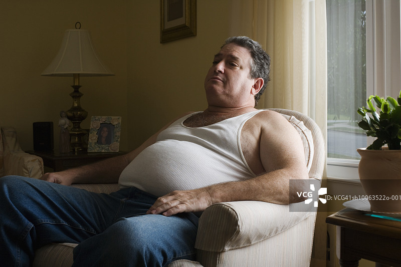 中年肥胖男人坐在扶手椅上图片素材