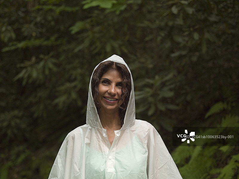 穿着白色雨衣微笑的中年妇女肖像图片素材