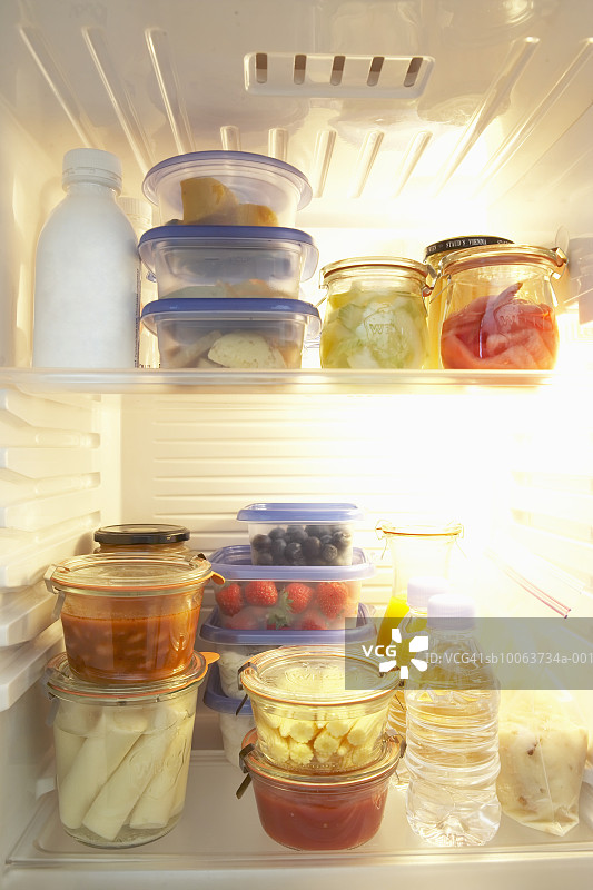 打开的冰箱，里面有装在塑料容器中的食物图片素材