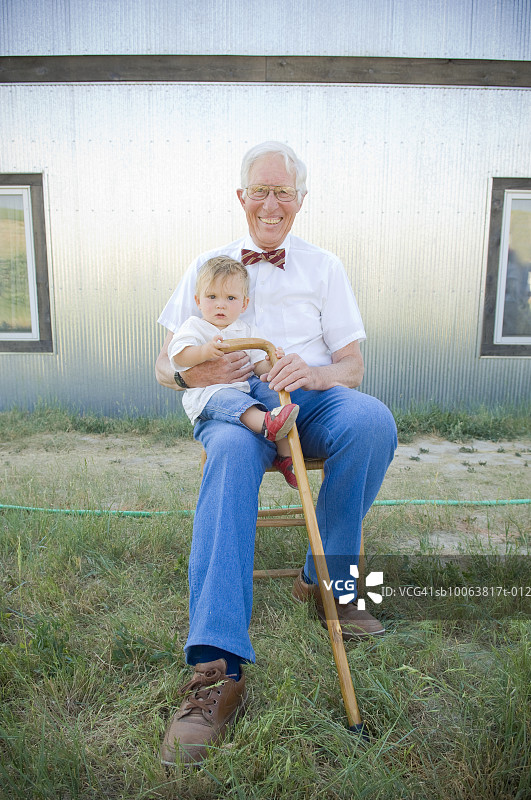 户外祖父抱着婴儿孙子（8-12个月）的肖像图片素材