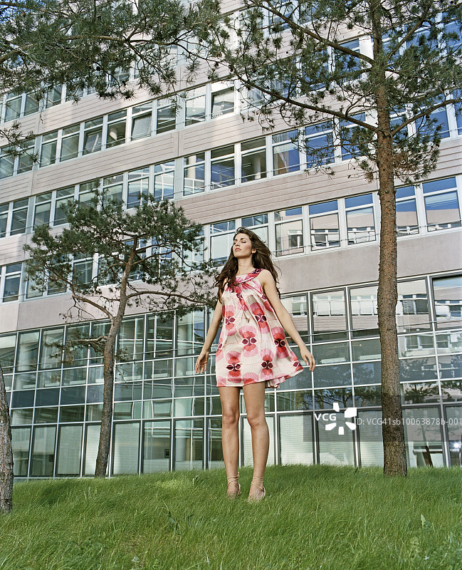 少女站在草地上闭着眼睛图片素材