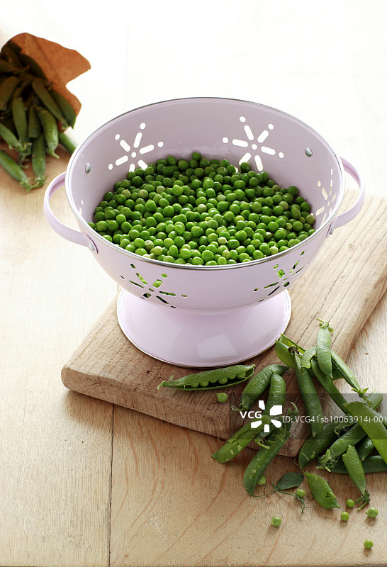 漏勺里的花园豌豆和豌豆荚图片素材