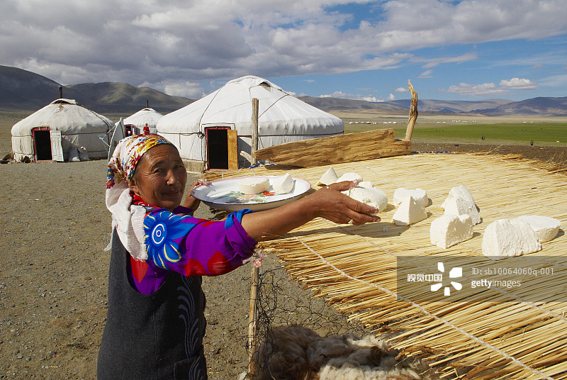 在屋顶晾晒奶酪的女人图片素材