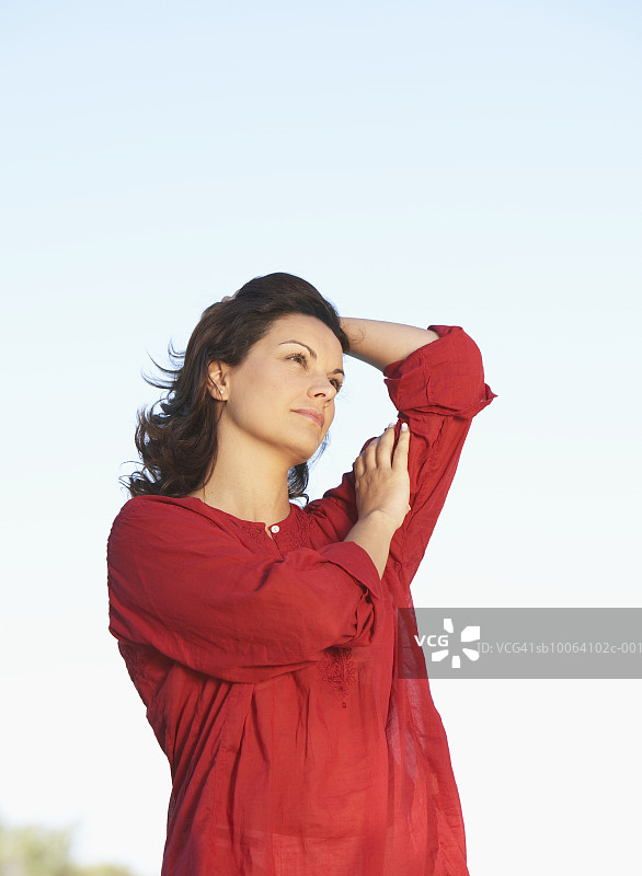 仰视天空下的年轻女子图片素材