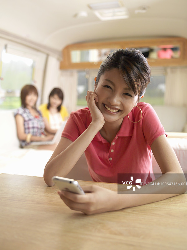 手持手机的年轻女性肖像（背景虚化）图片素材