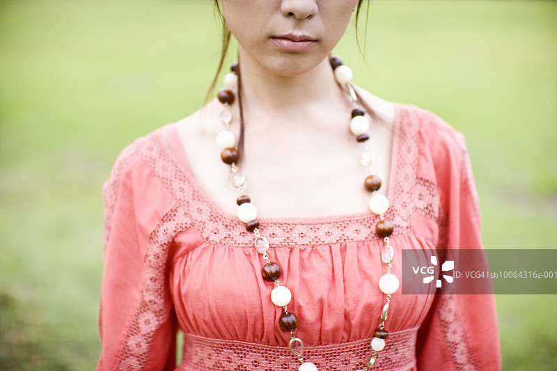 身穿粉色连衣裙和项链的年轻女子，中段图片素材