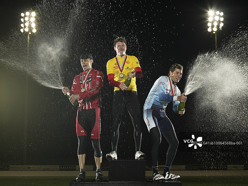 站在领奖台上喷洒香槟的骑行者图片素材