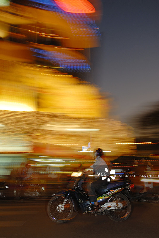 越南西贡夜景：城市街道上骑摩托车的人们（虚化效果）图片素材
