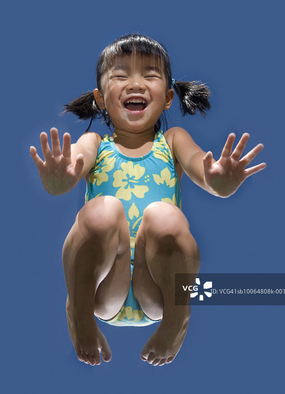 跪在玻璃上欢笑的幼女（3-4岁），由下往上视角图片素材