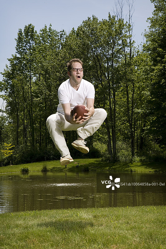 男子跳跃接橄榄球图片素材