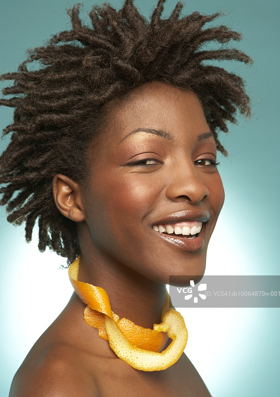 年轻女人脖子上挂着橘子皮，微笑，特写图片素材